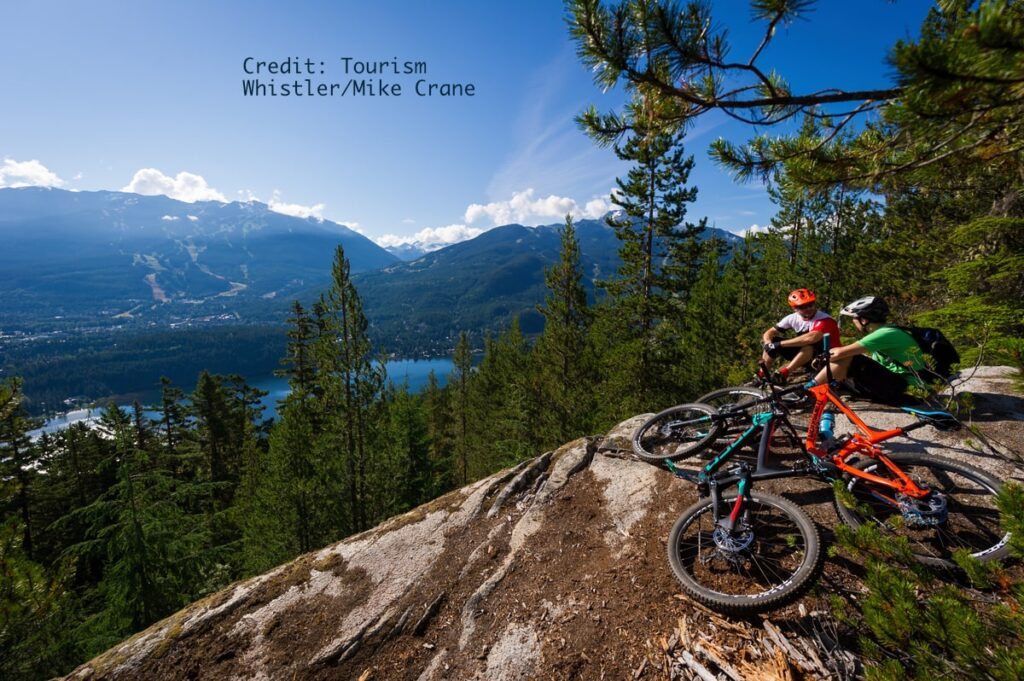 Two mountain bikers taking in the view over Squamish