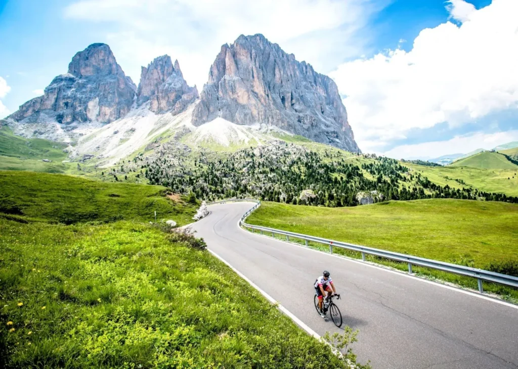 cyclists riding with dolomite peaks in background