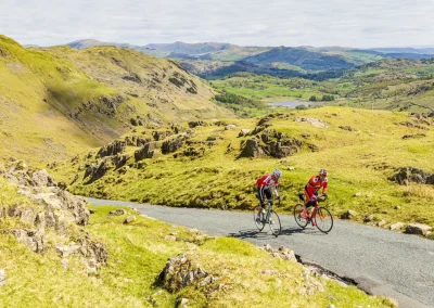 cyclists riding up hill in lake district