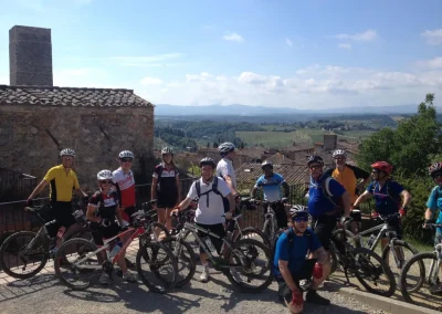 cyclists overlooking ancient Tuscan town