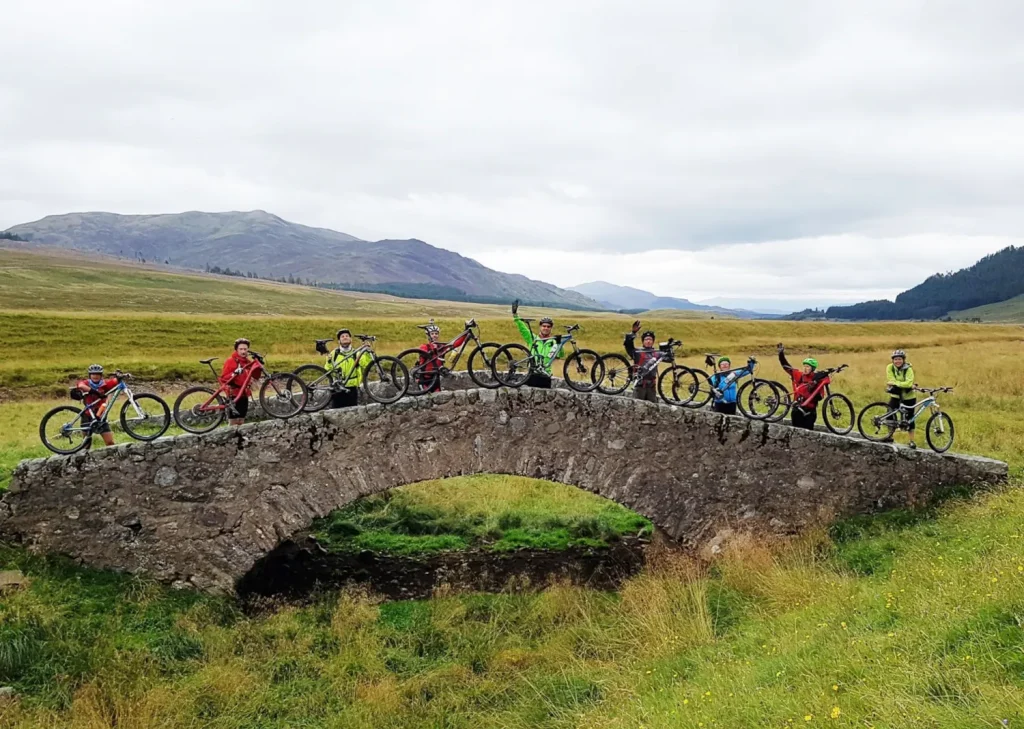 cyclists stopped atop ancient Scottish bridge